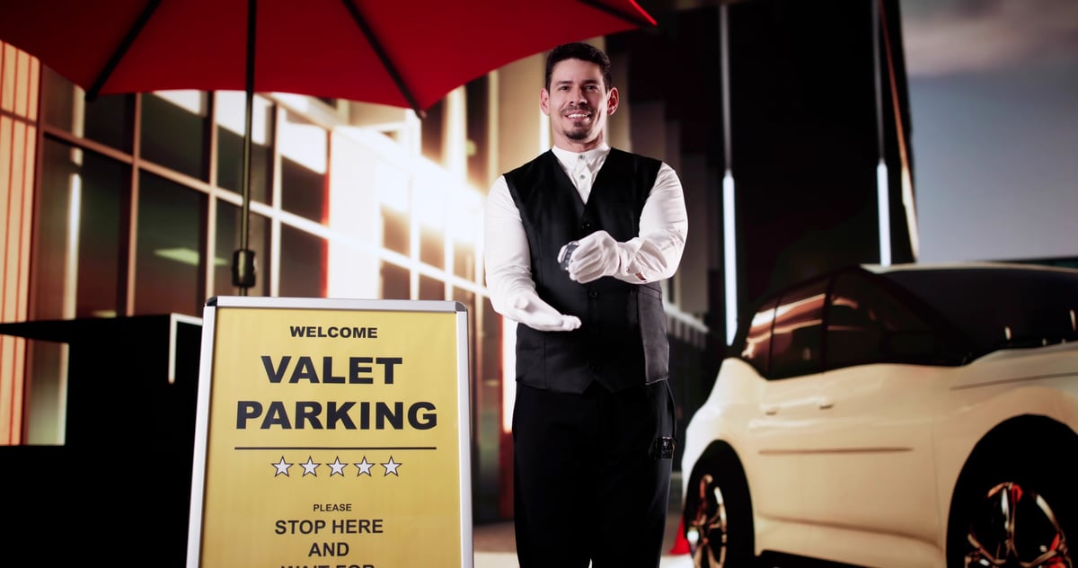 Professional male valet holding car keys outdoors
